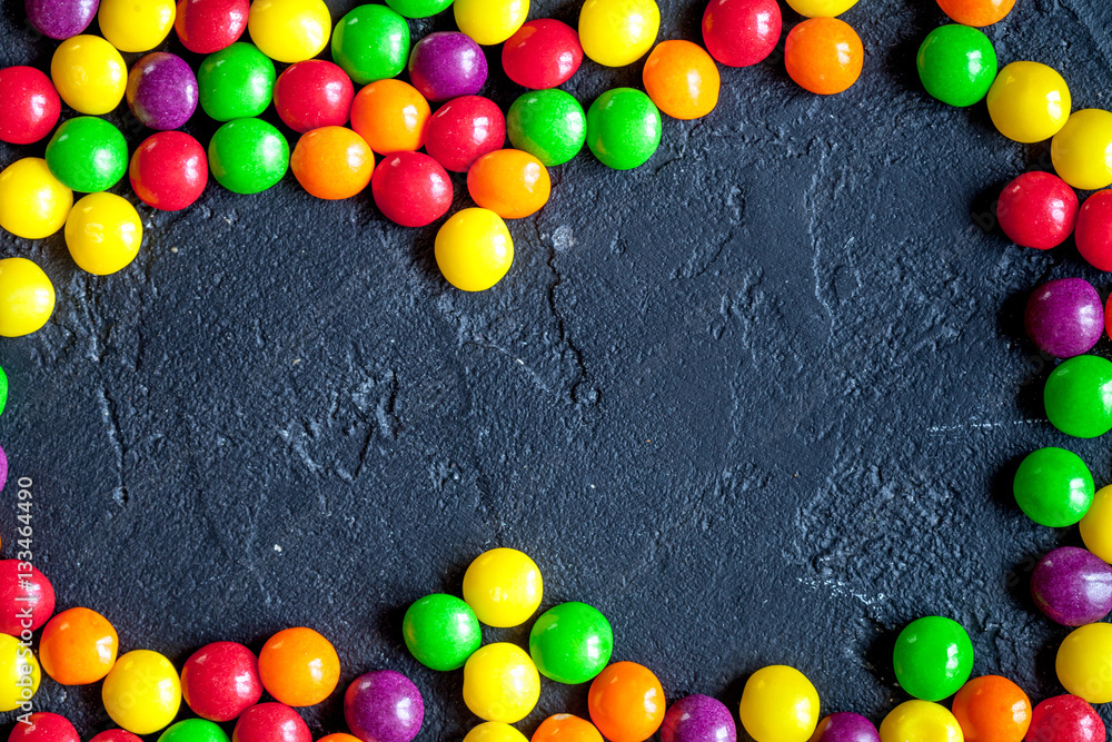 sweets and sugar candies on dark background top view