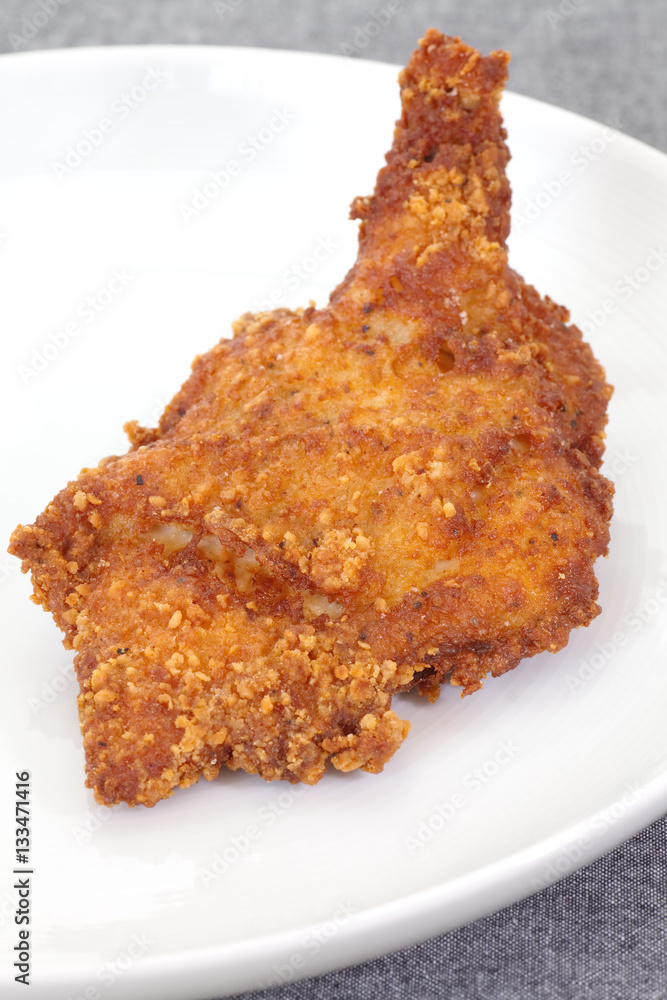 Delicious crisp deep fried chicken leg on white plate