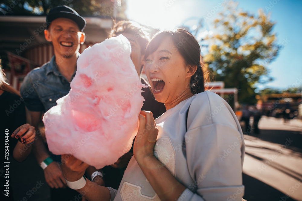 Young friends eating cotton candy outdoors