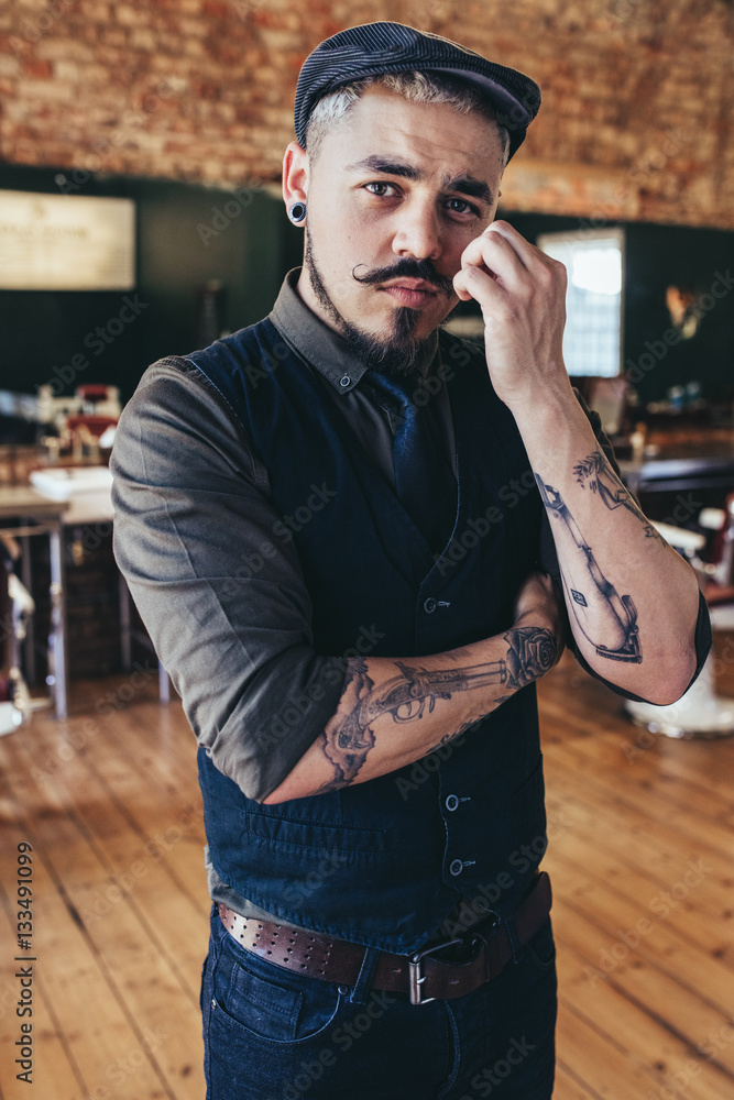 Stylish young male barber in barbershop