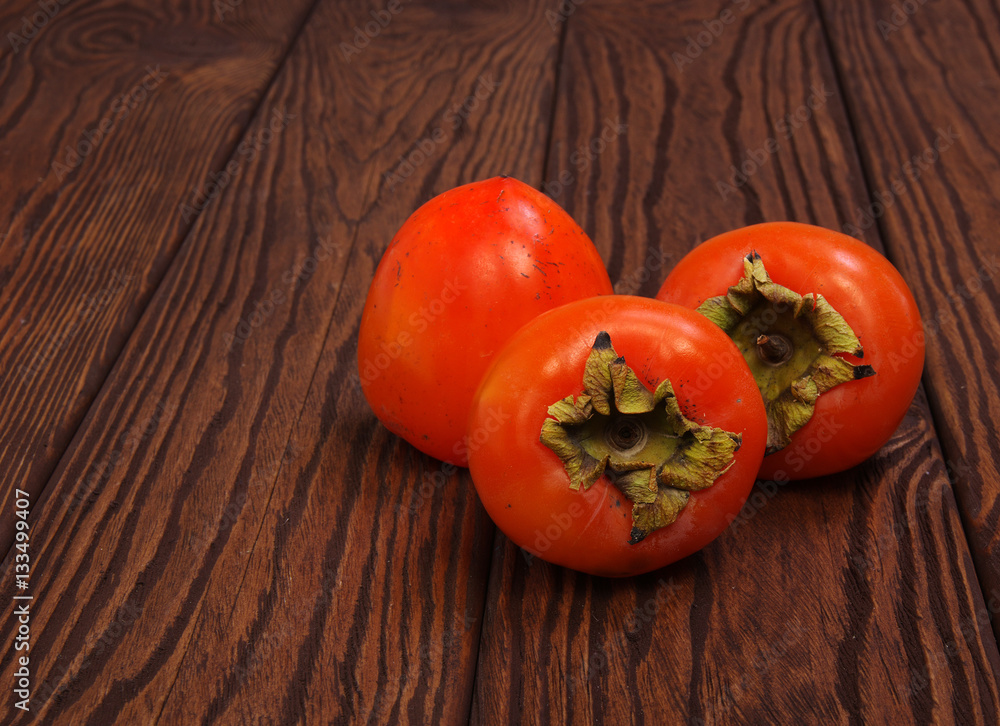  persimmon fruit on wooden background