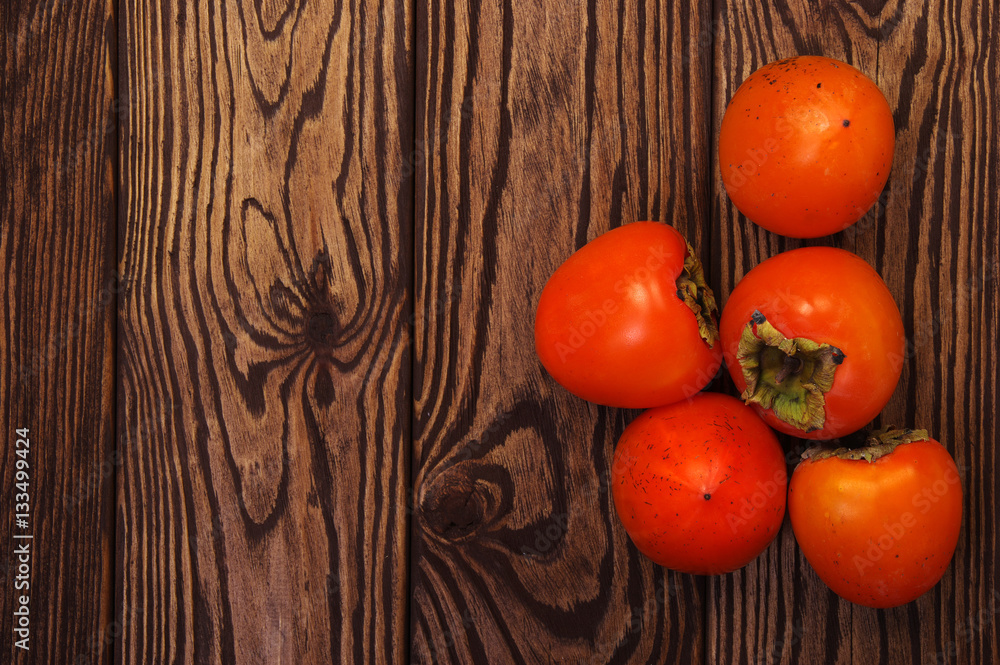  persimmon fruit on wooden background