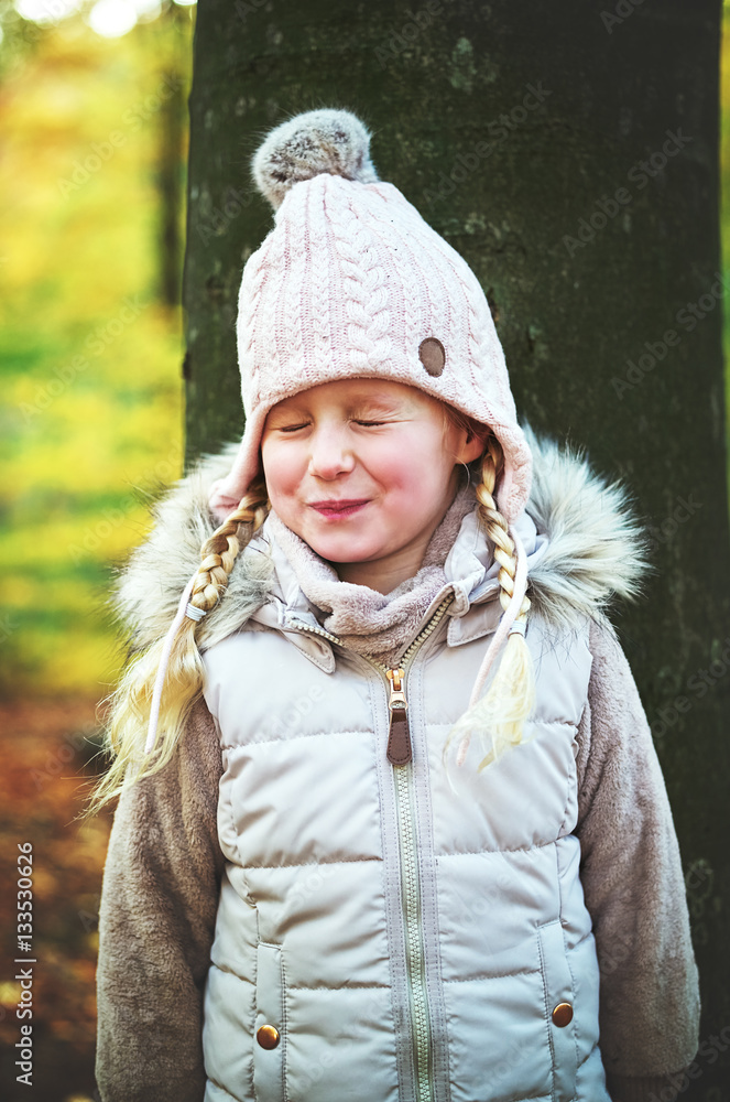 Dreaming little girl standing in the forest