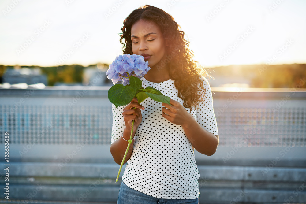 Black woman smelling a pretty flower