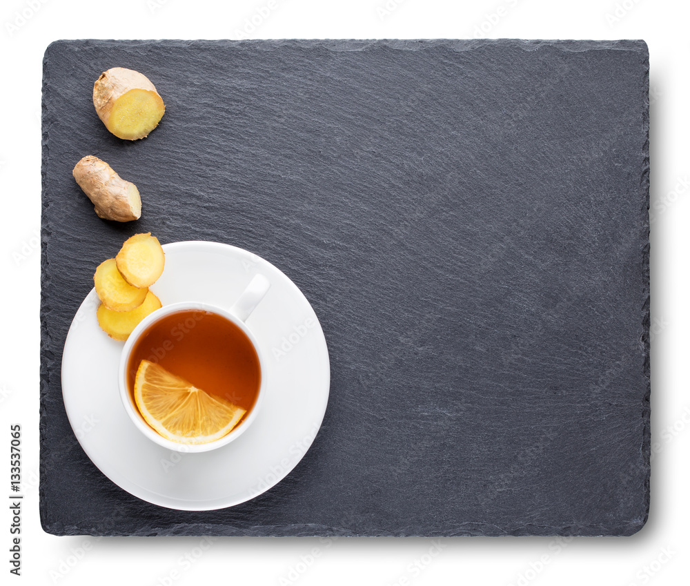 Tea with lemon and ginger root on slate blackboard