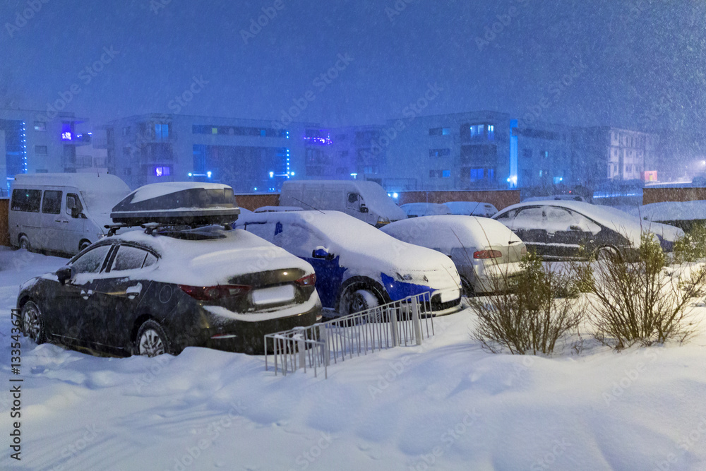 Snowy street with cars after winter snowfall in Poland