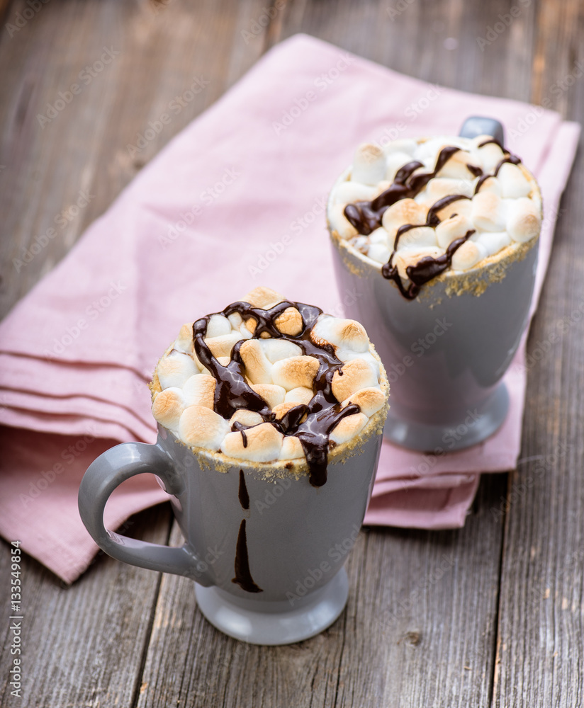 Smores drink. Two mugs of hot chocolate with marshmallows on a wooden table. Cocoa.