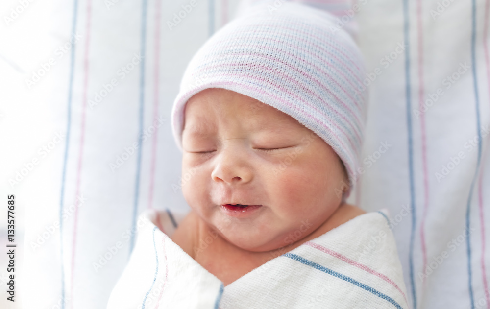 Newborn infant baby boy lying in a hospital bed