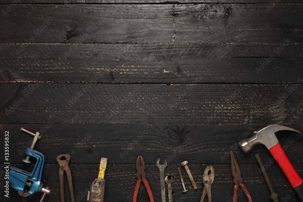 Old working tools  on a dark black wood background