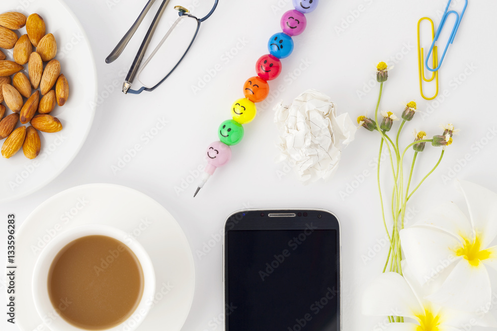 Top view of cell phone with coffee cup and office supplies 