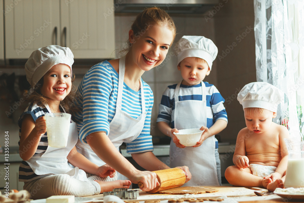 happy family in kitchen. mother and children preparing dough, ba