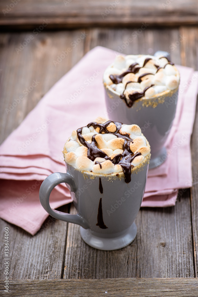 Smores drink. Two mugs of hot chocolate with marshmallows on a wooden table. Cocoa.