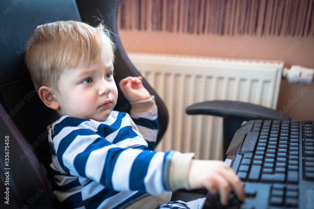 Little boy typing on the computer keyboard