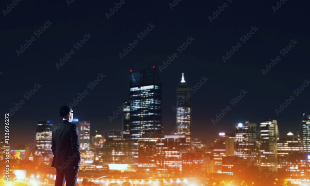 Businessman viewing night glowing city