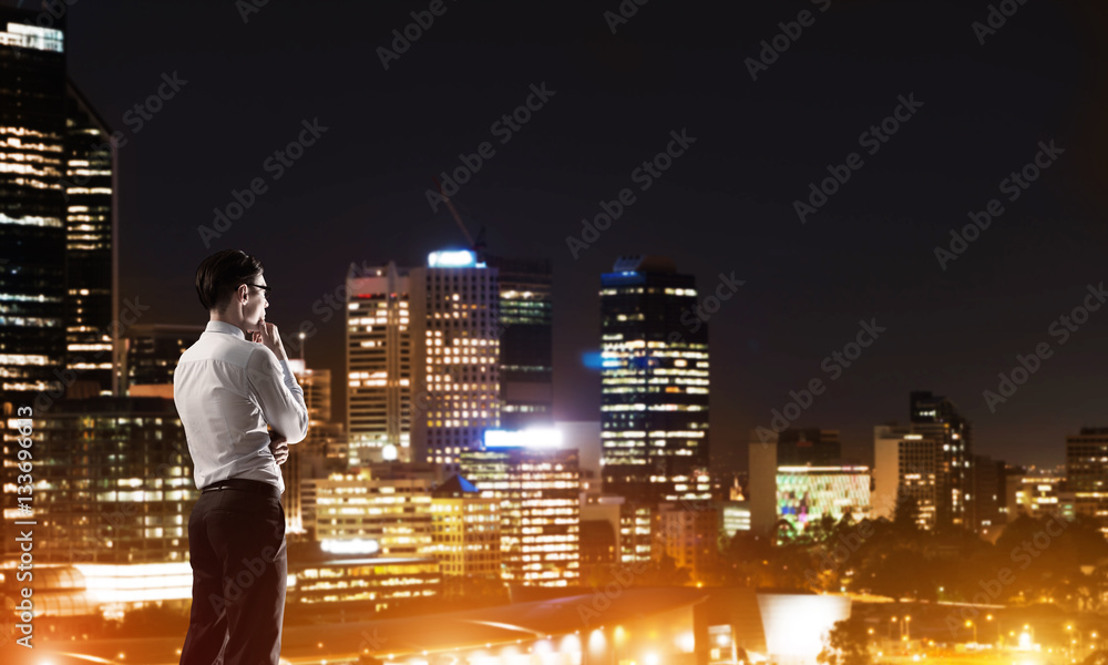 Businessman viewing night glowing city