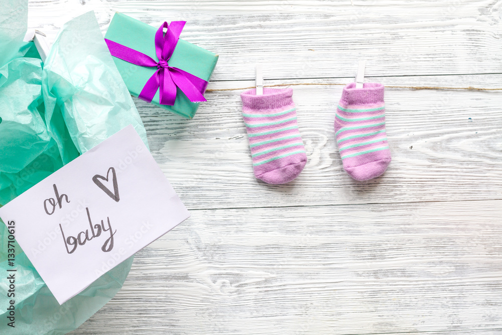 babys bootees and gift box on wooden background