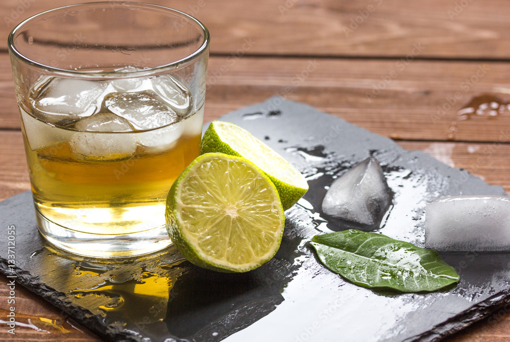 glass of whiskey on wooden background