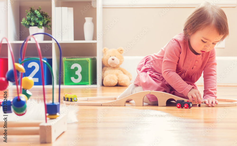 Happy toddler girl playing with toys