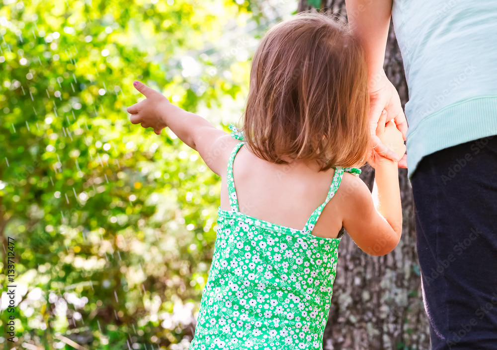 Toddler girl holding hands with her mother