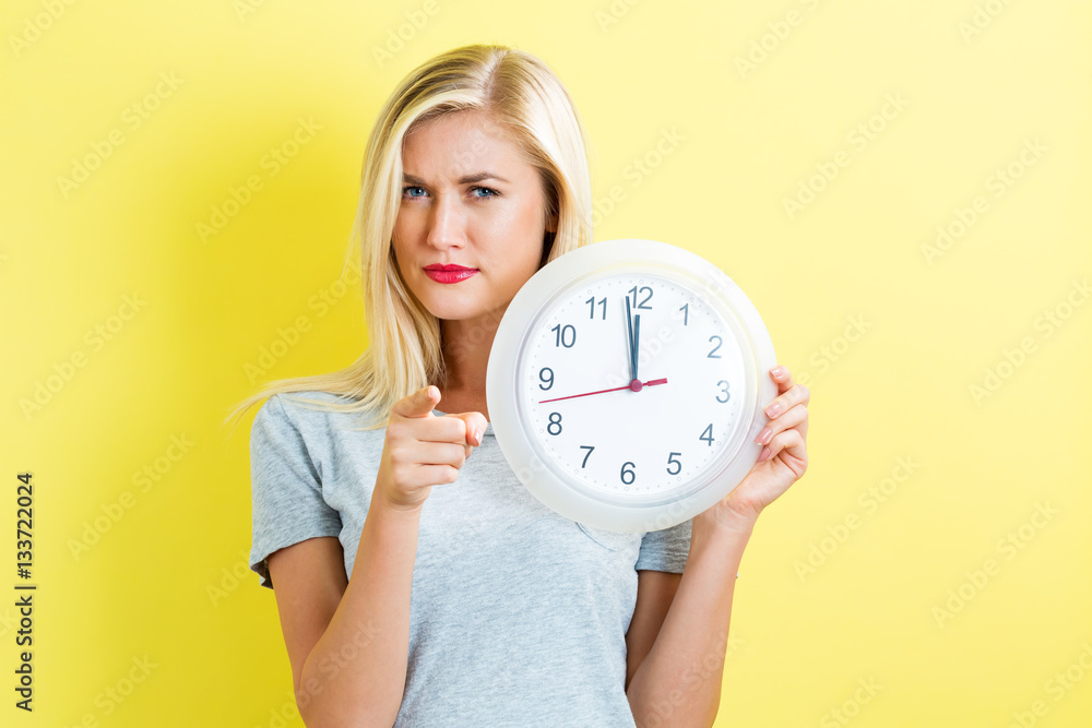  Woman holding clock showing nearly 12