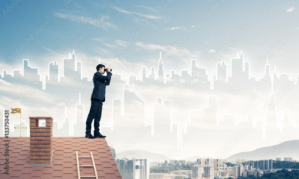 Businessman standing on roof and looking in binoculars. Mixed me