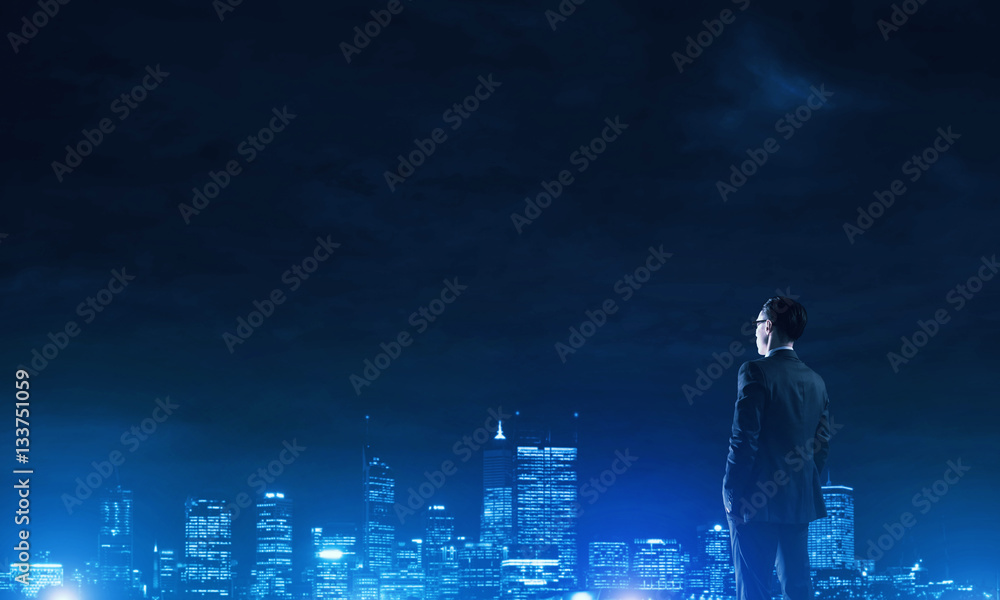 Businessman viewing night glowing city