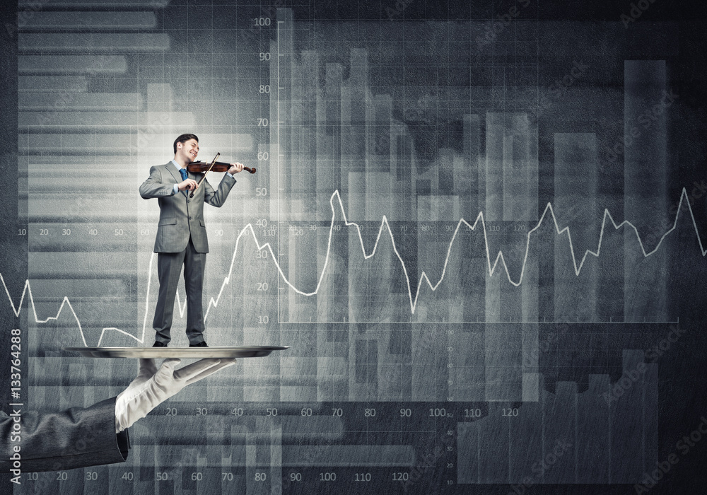 Businessman on metal tray playing violin against graphs and diagrams background