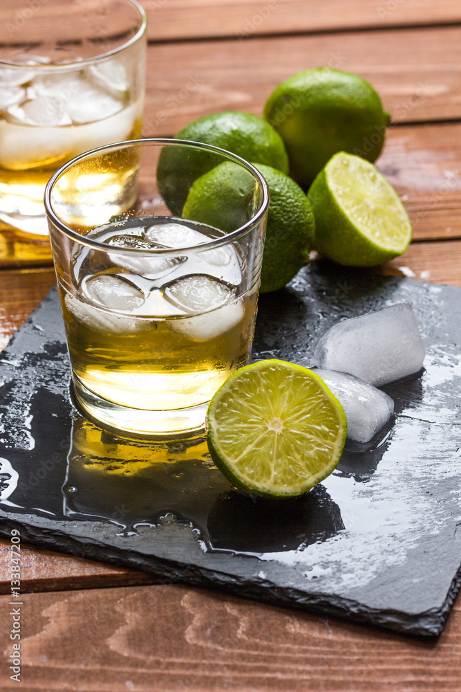 glass of whiskey on wooden background