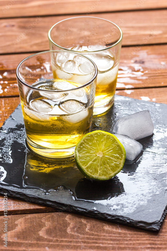 glass of whiskey on wooden background