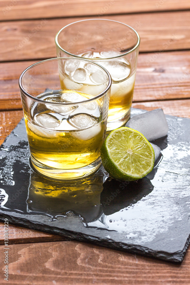 glass of whiskey on wooden background