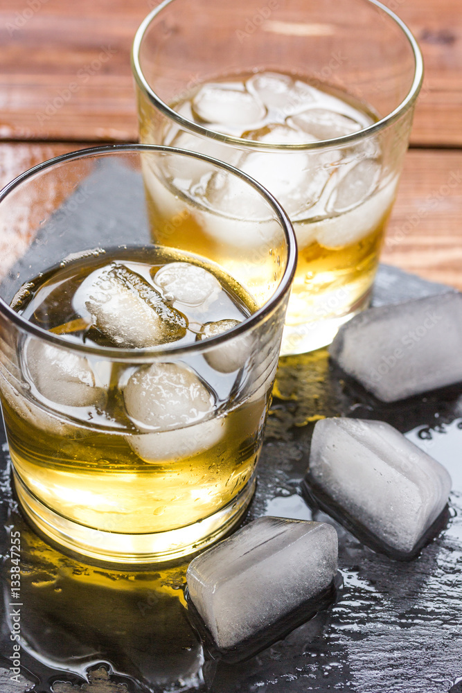 glass of whiskey on wooden background