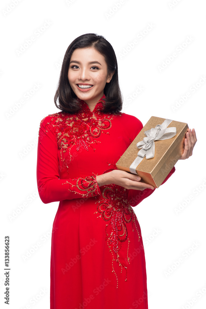 Vietnamese young woman in Ao Dai dress holding gift box.