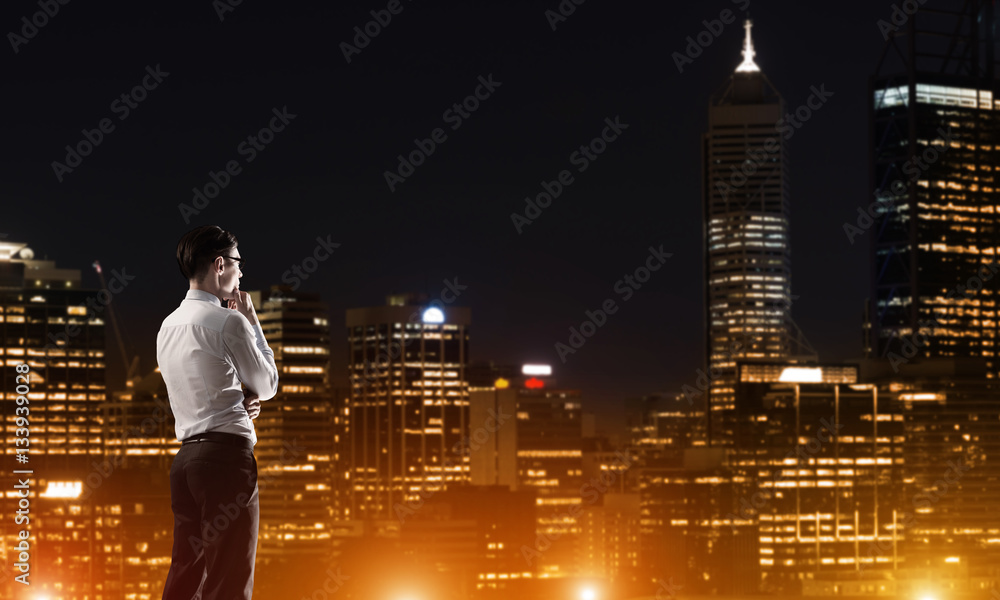 Businessman viewing night glowing city