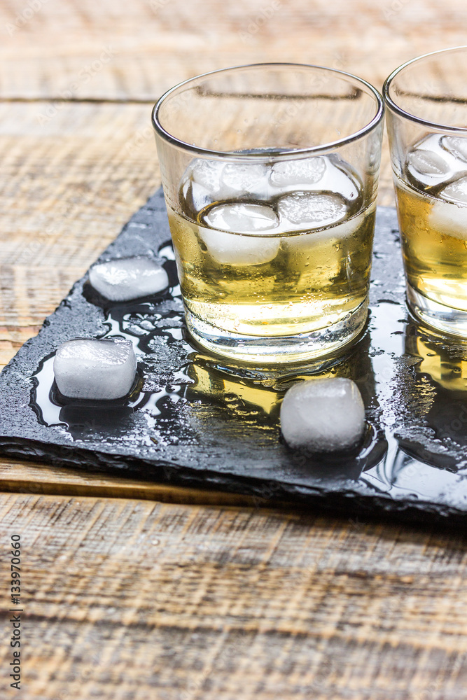 glass of whiskey on wooden background