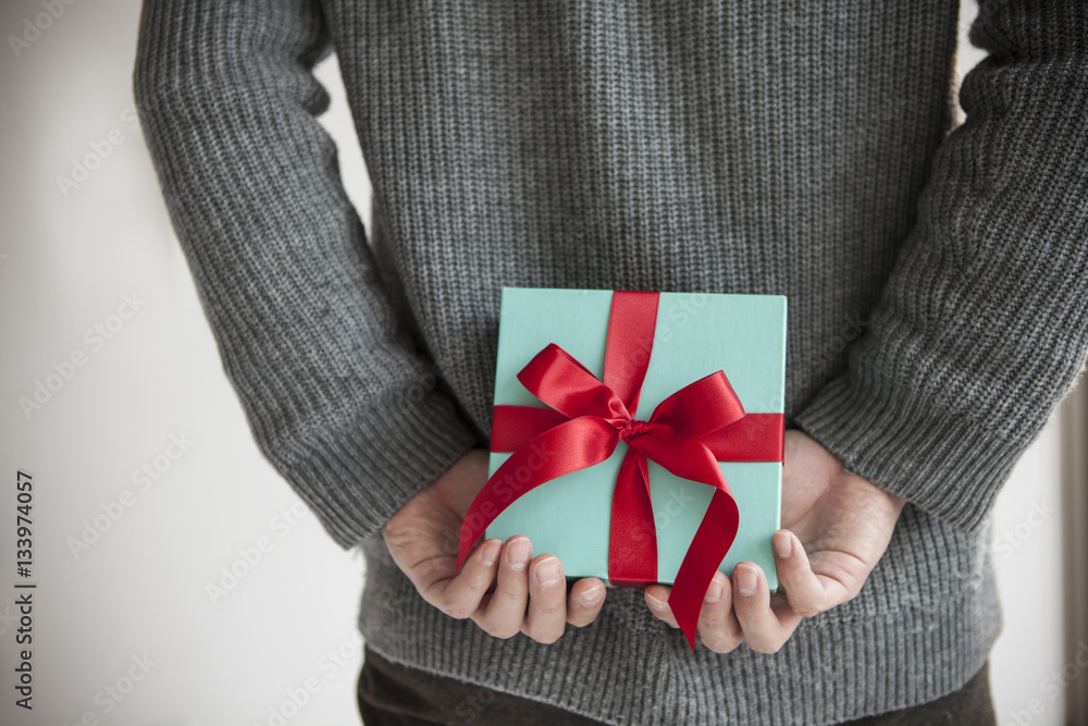 Men hide gift box behind