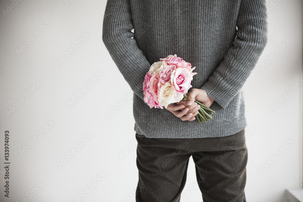 Men hide cute bouquets behind