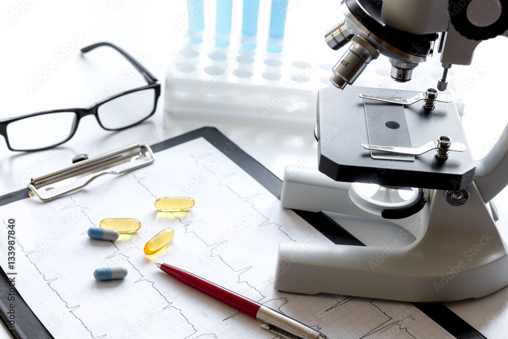 doctors desk with microscope and test tubes