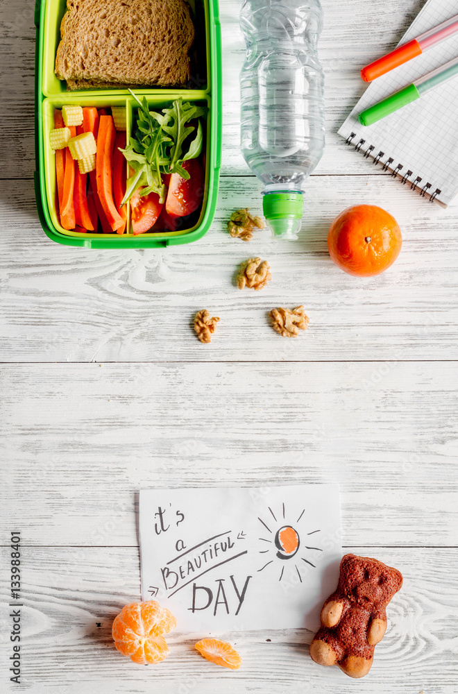 kid menu lunchbox for school top view on wooden background