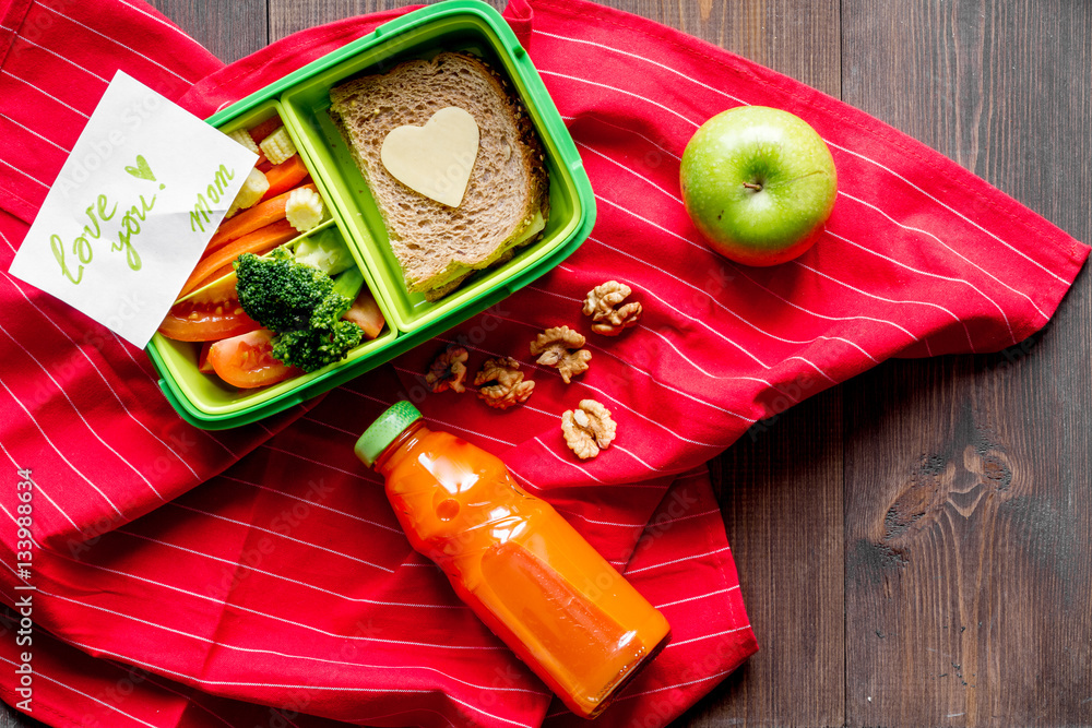 green lunch box for kid on wooden background top view