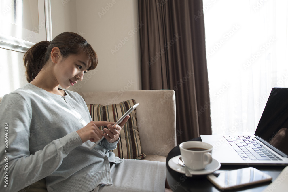 那个女人坐在沙发上用平板电脑