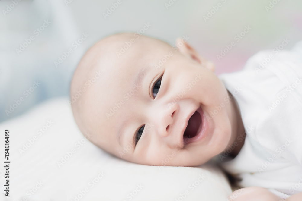 Portrait of cute 3 months Asian baby boy lying down on a blanket