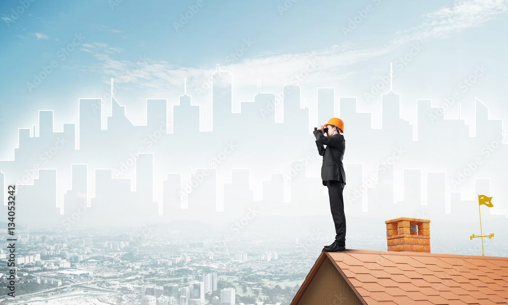 Engineer man standing on roof and looking in binoculars. Mixed media