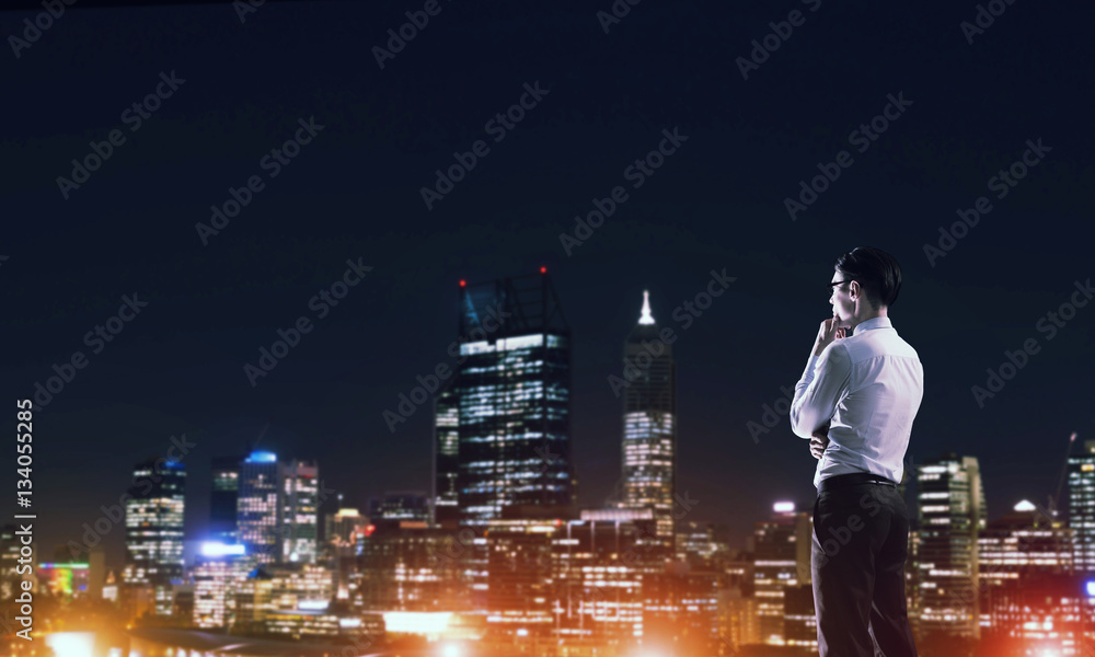 Businessman viewing night glowing city