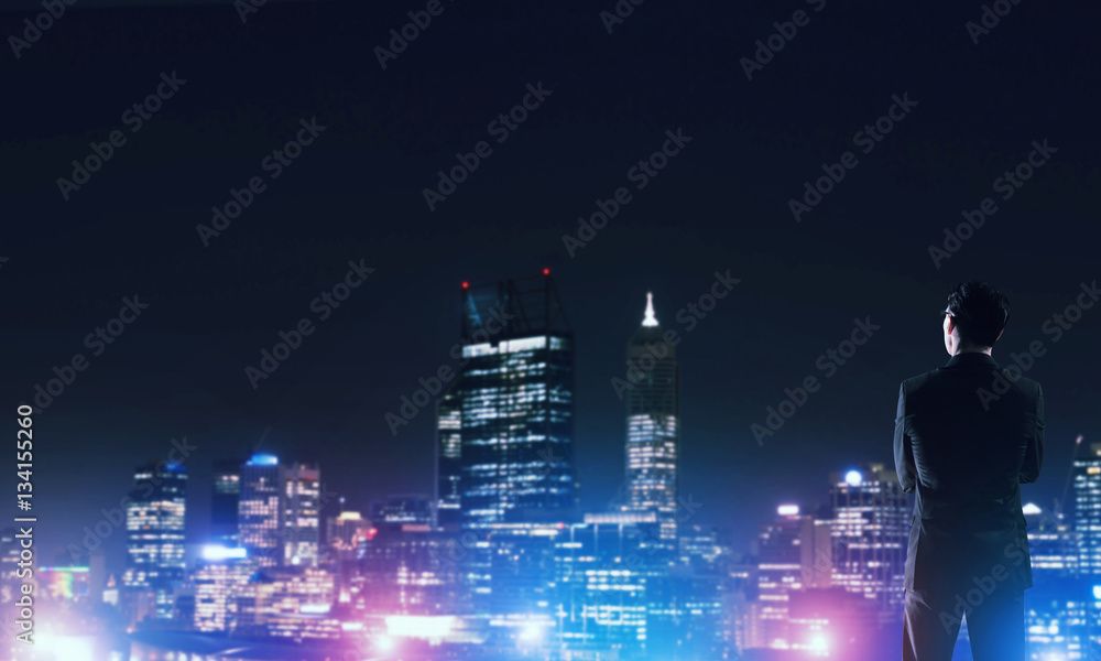 Businessman viewing night glowing city