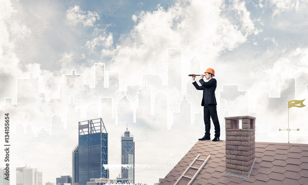 Engineer man standing on roof and looking in spyglass. Mixed med