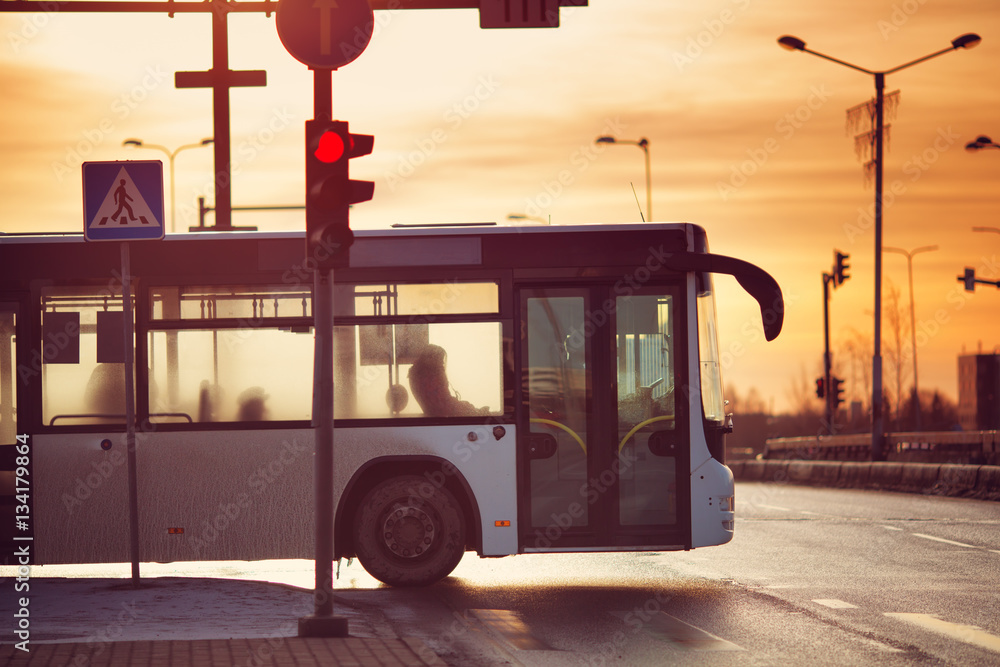 Bus moving on the road in city in early morning. View to the traffic with trafficlights and transpor