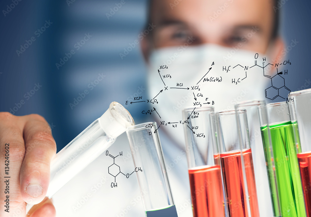 Young scientist mixing reagents in glass flask in clinical laboratory