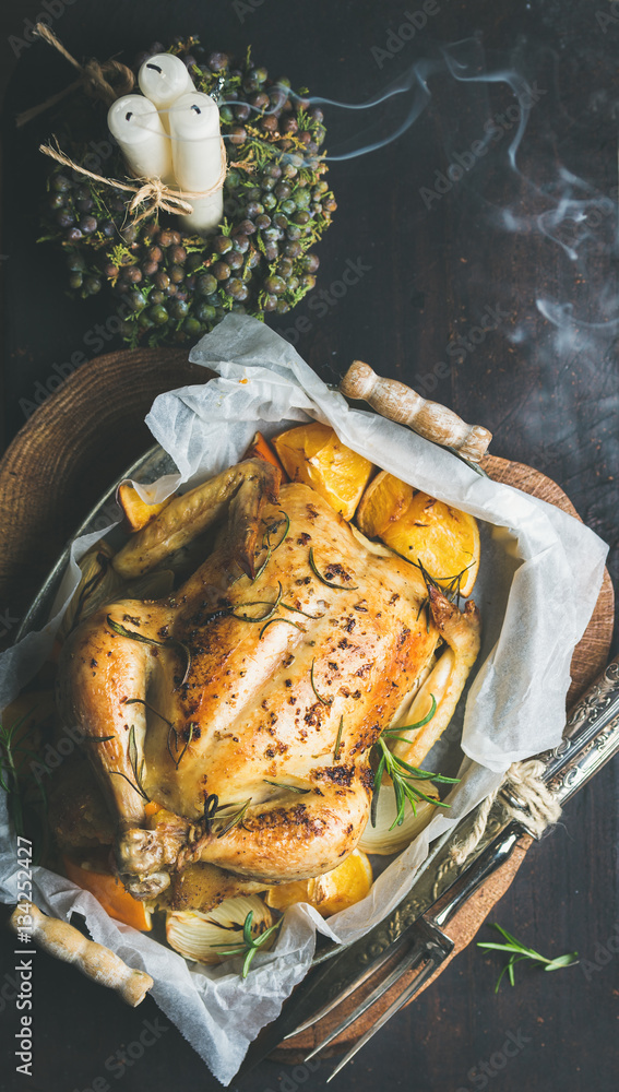 Christmas holiday table set with roasted whole chicken stuffed with oranges, bulgur and rosemary, de