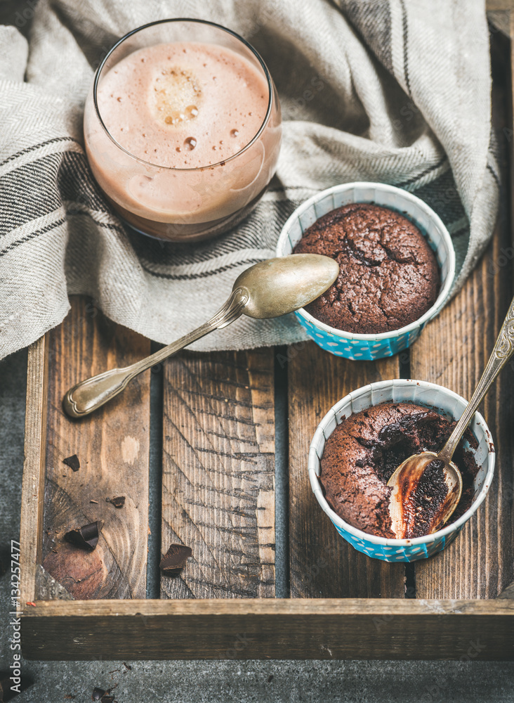 Chocolate souffle in individual blue baking cups and chocolate mocha coffee in glass in rustic woode