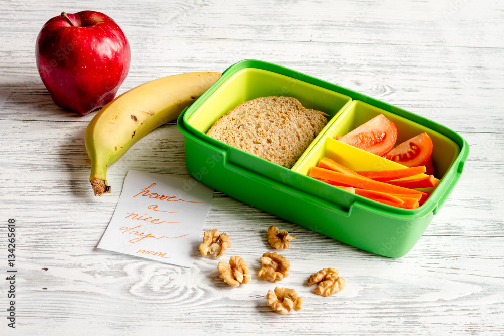 lunch box for kid with fresh vegetables on wooden background